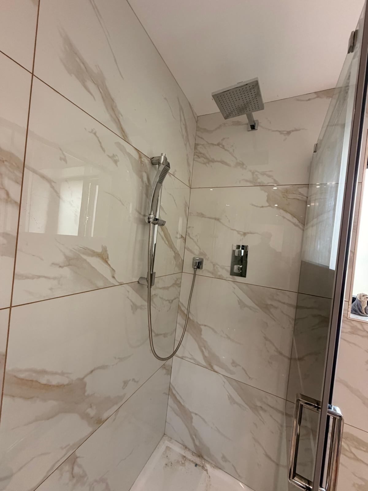 Walk-in shower with marble tiling and a rainfall shower head