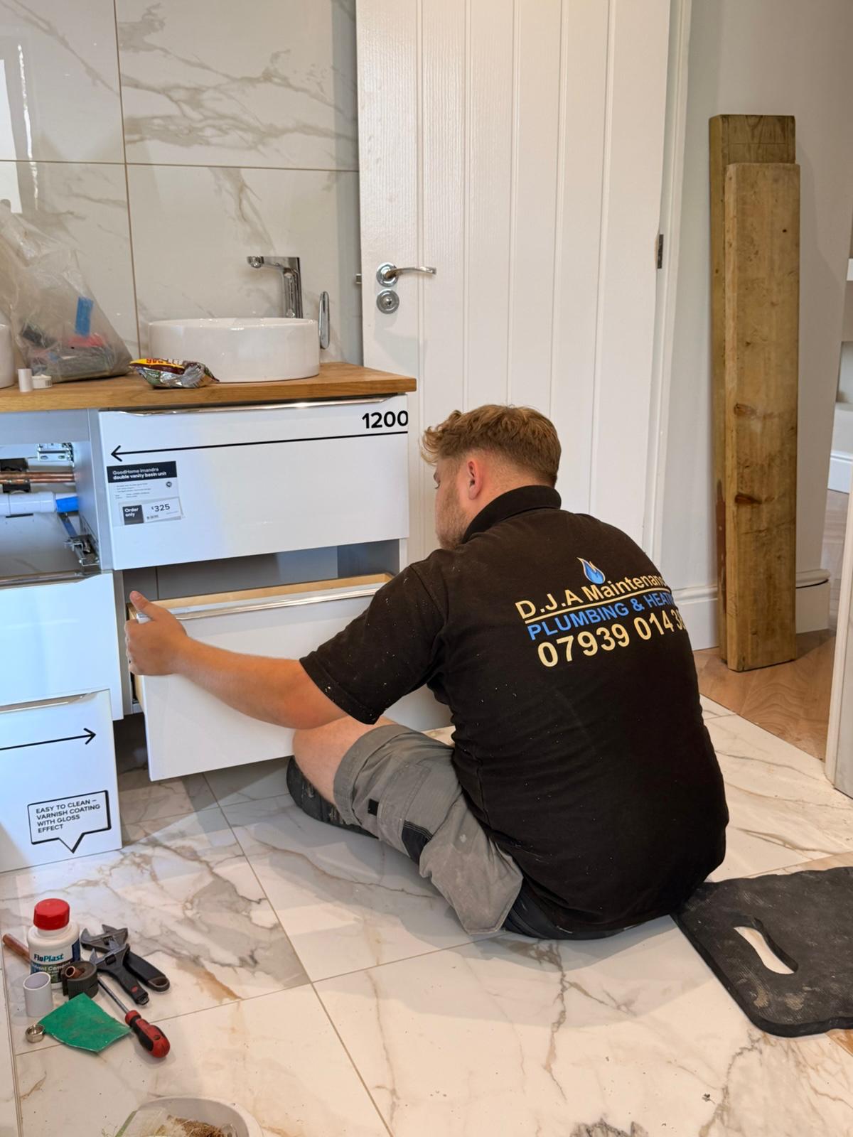 DJA Maintenance engineer fitting a vanity unit in a marble bathroom